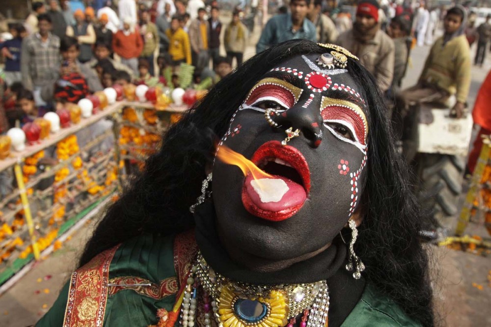 A man dressed as Hindu goddess Kali, the goddess of power, performs with a burning camphor tablet on his tongue during a religious procession ahead of the "Kumbh Mela", or Pitcher Festival, in the northern Indian city of Allahabad January 6, 2013. During the festival, hundreds of thousands of Hindus take part in a religious gathering at the banks of the river Ganges. The festival is held every 12 years in different Indian cities. REUTERS/Jitendra Prakash (INDIA - Tags: RELIGION ANNIVERSARY TPX IMAGES OF THE DAY) ORG XMIT: DEL08