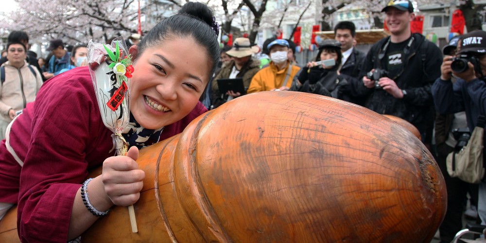 KAWASAKI, JAPAN - APRIL 04: A visitor rides on a wooden phallic figure during the Kanamara Festival, or the Utamaro Festival, near Wakamiya Hachimangu Shrine on April 4, 2010 in Kawasaki, Japan. The annual feritility festival, held traditionally in the cherry blossom season since the Edo era (1603-1868), is said to encourage fertility and bring harmony to married couples. In recent times the festival has raised awareness of AIDS prevention. (Photo by Koichi Kamoshida/Getty Images)