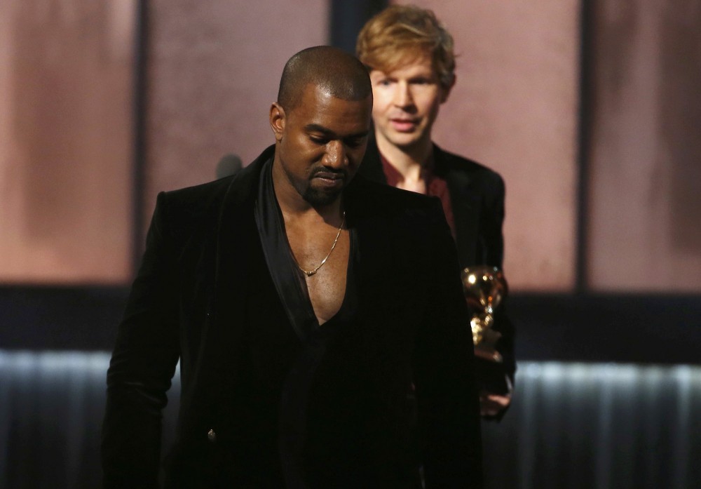 Beck watches Kanye West after Beck won album of the year for "Morning Phase," at the 57th annual Grammy Awards in Los Angeles