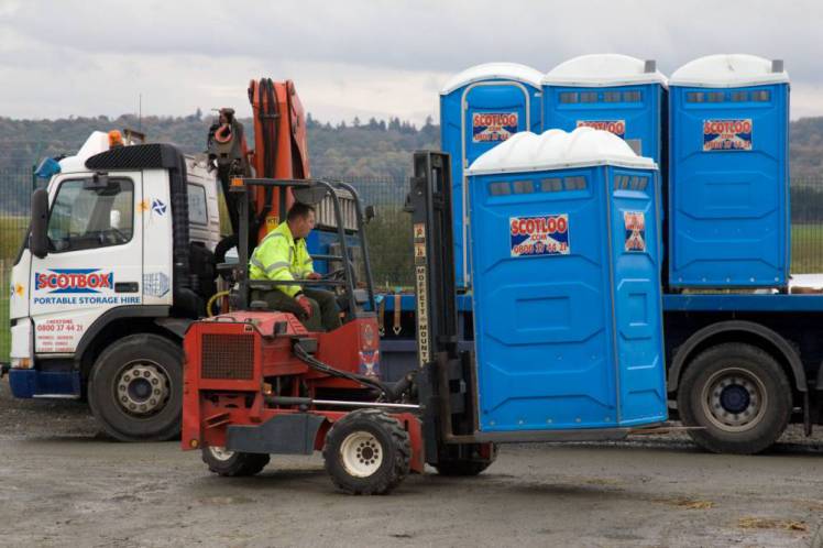 BFXBNC Forklift unloading portaloo from a lorry